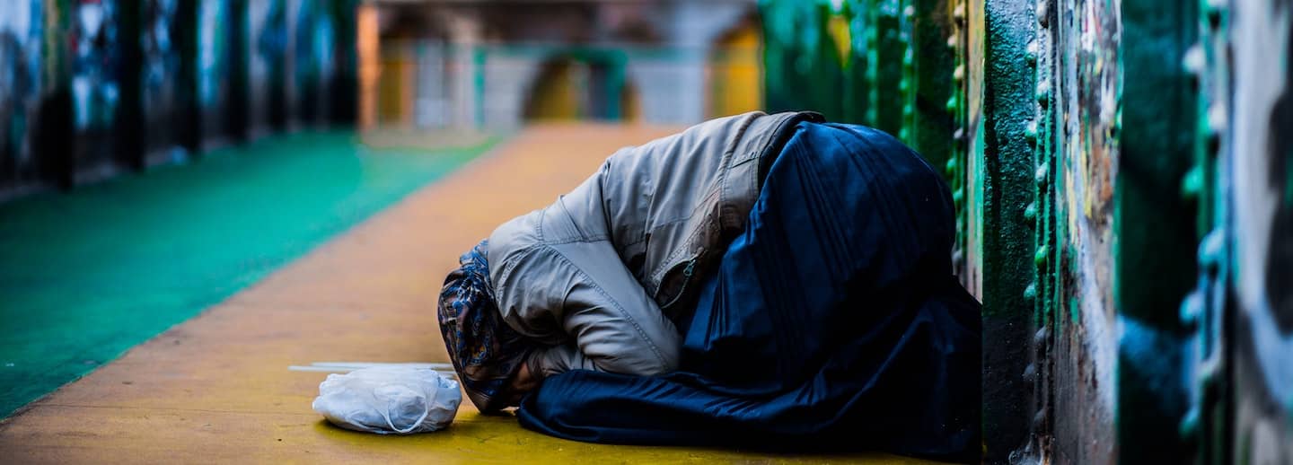 A lonely woman kneeling on the floor hiding her face in her hands